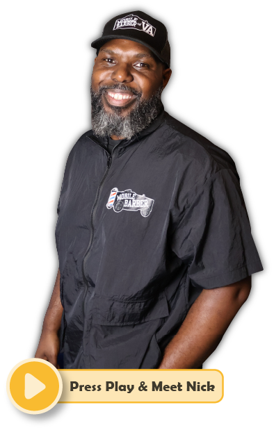 A black male, mobile barber, smiling with his hands in his pockets